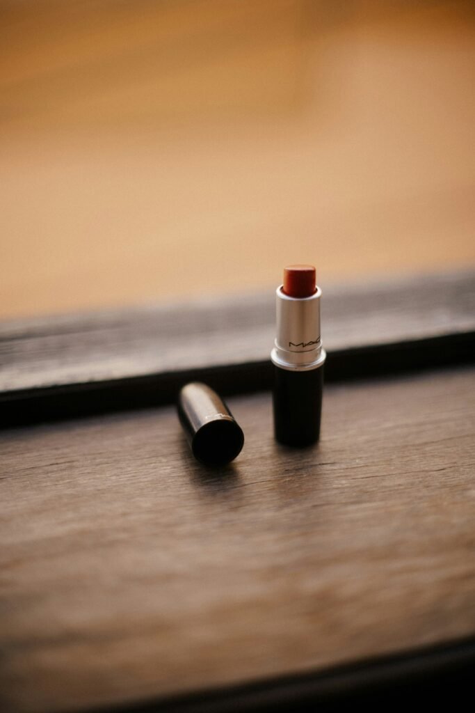 Lipstick bullets standing on a dark wooden surface in warm light